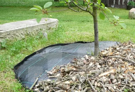 rollo de malla antihierbas negra colocada en el césped de jardín