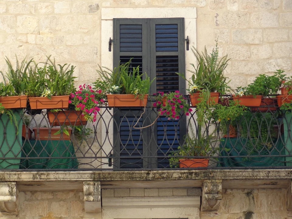 macetas y jardineras de plástico marrones en balcón